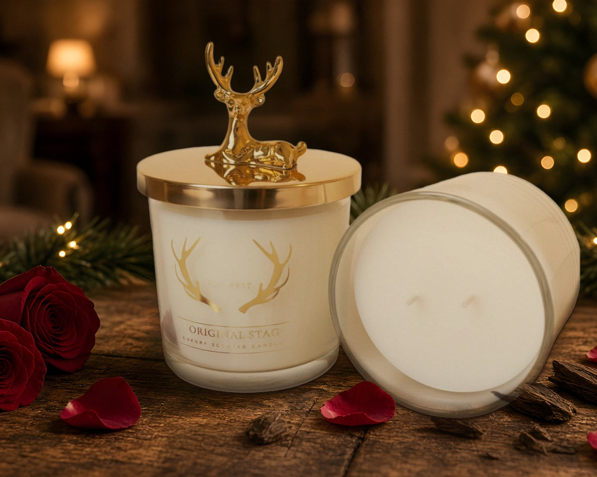 Original Stag Rose & Oud candles with gold stag lid, red roses and a lit Christmas tree